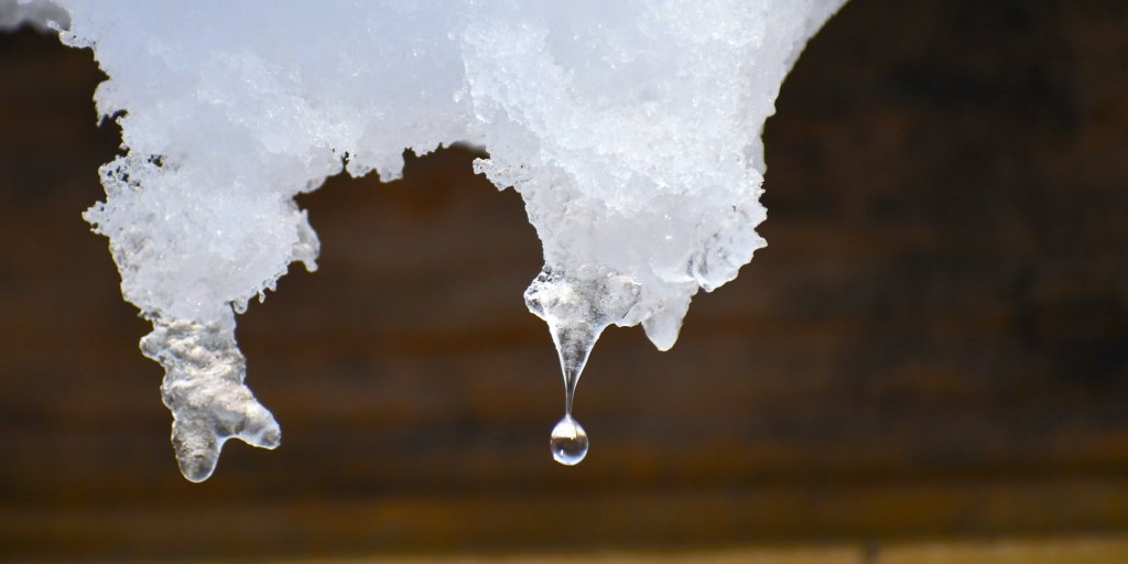 ذوبان الجليد في الربيع يقطر من سطح نزهة ذائب مليء بالثلوج.