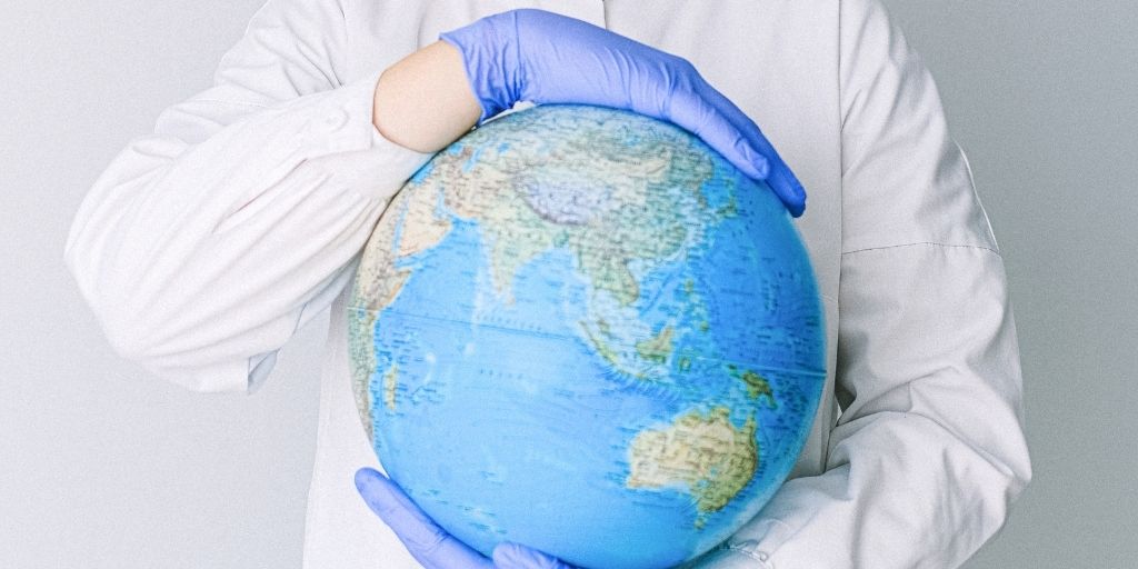 a medical worker holding a globe