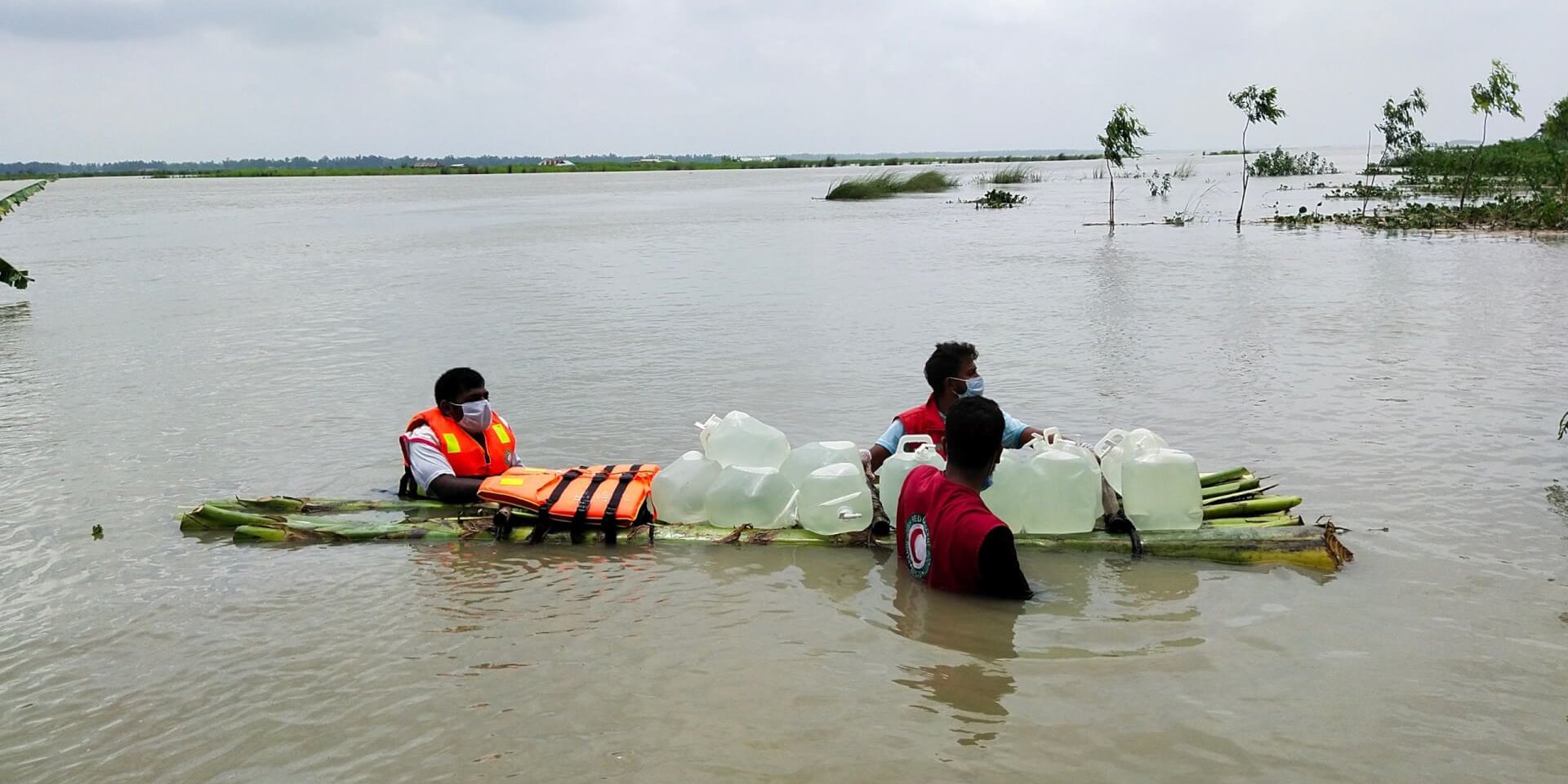 Bangladesh Red Crescent volunteers reaching stranded communities with clean water.