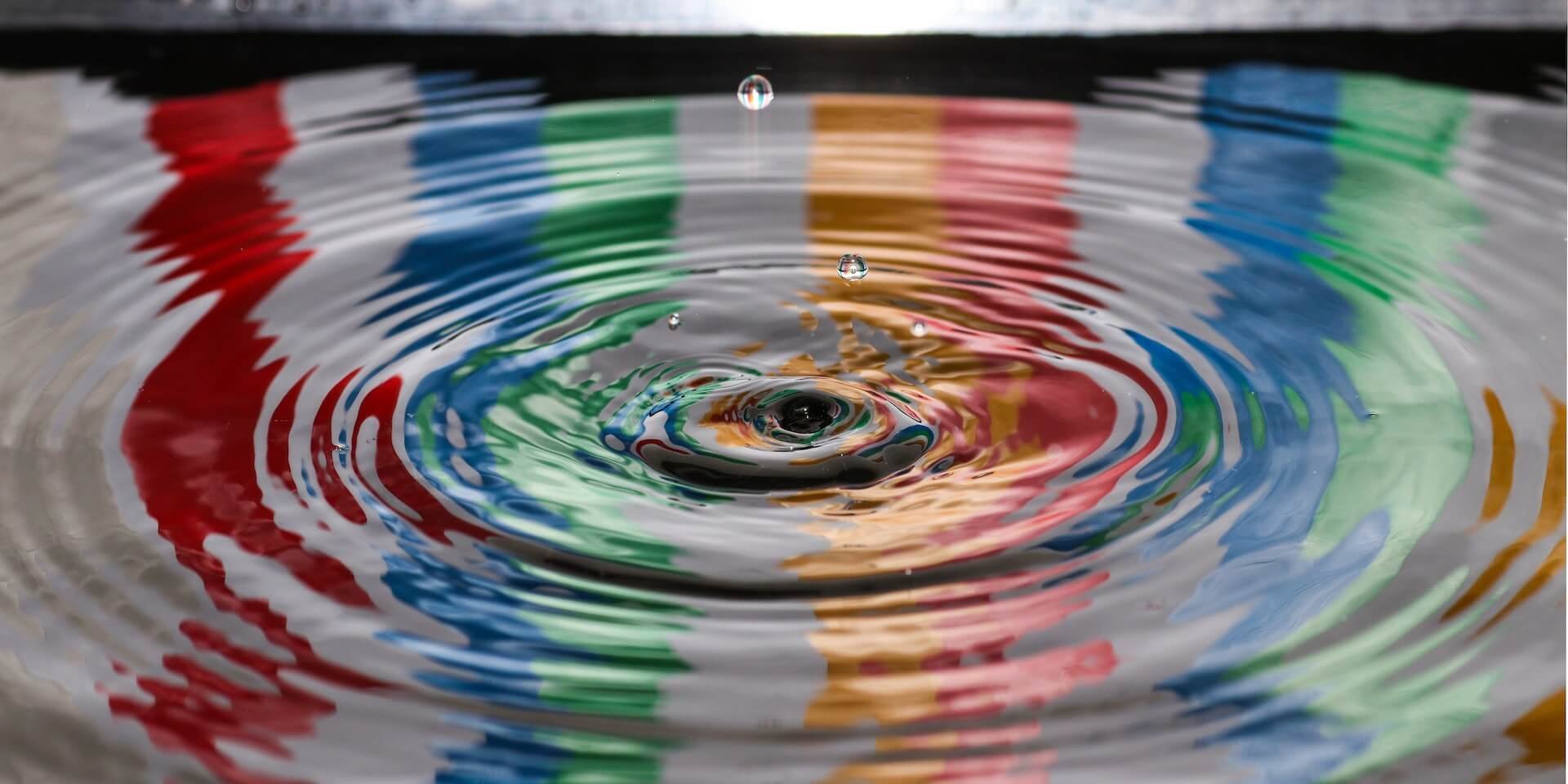 Water drop dropping in colorful waer