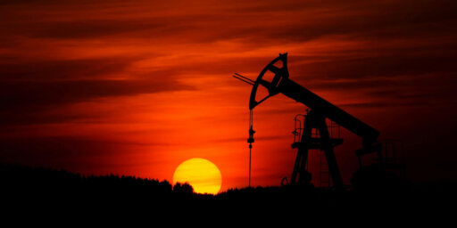 An oil drill rig during sunset