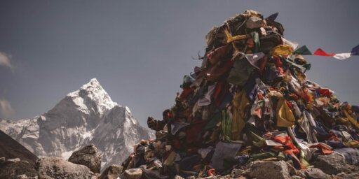 A photo of a pile of garbage with a snowy mountain the background