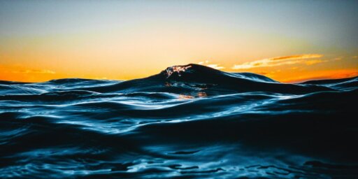 Una vista de las olas del océano durante el atardecer.