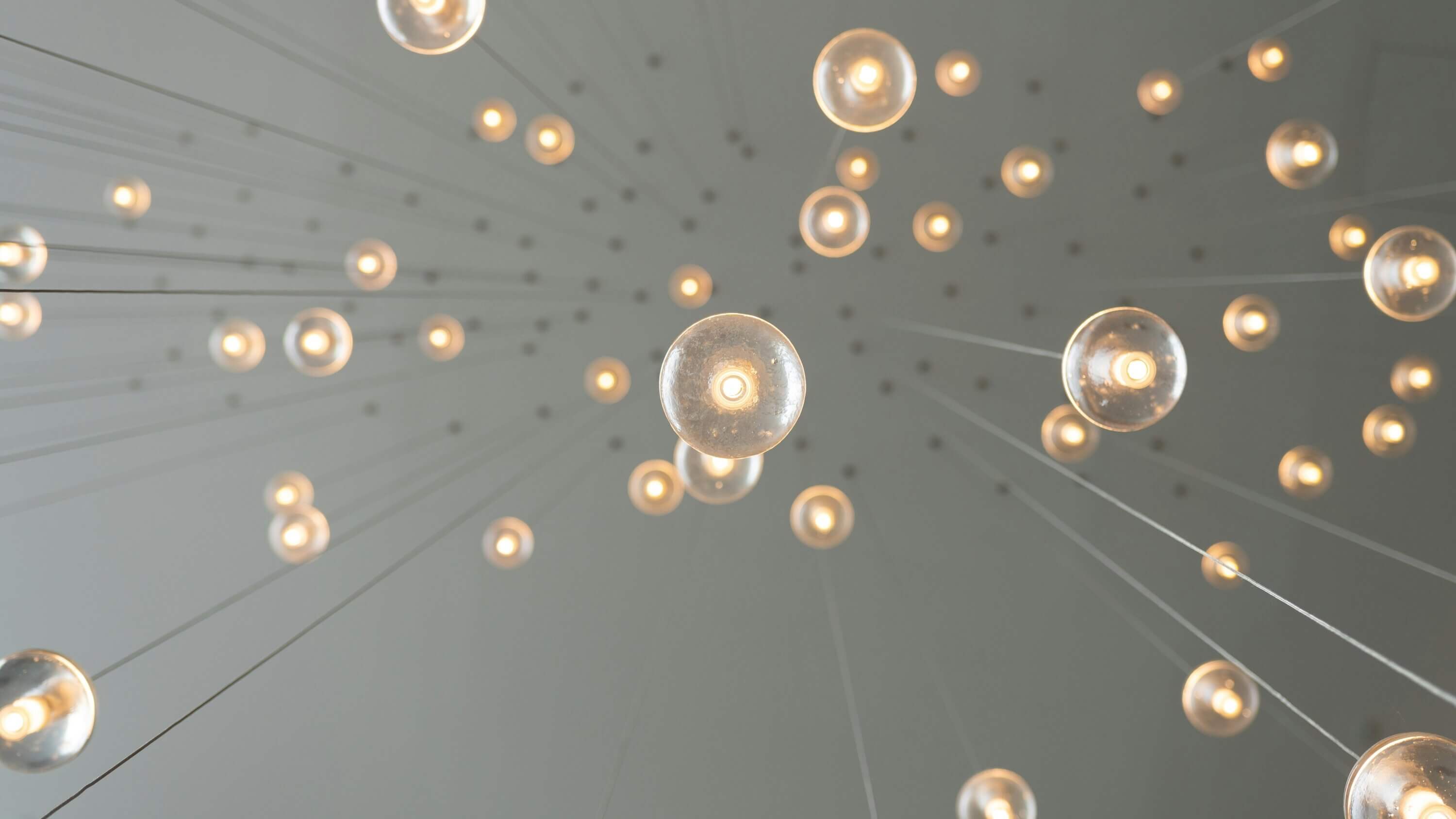Multiple light bulbs hanging from a ceiling