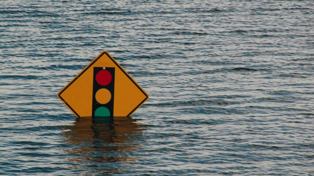 A traffic sign in water showing signs of flooding