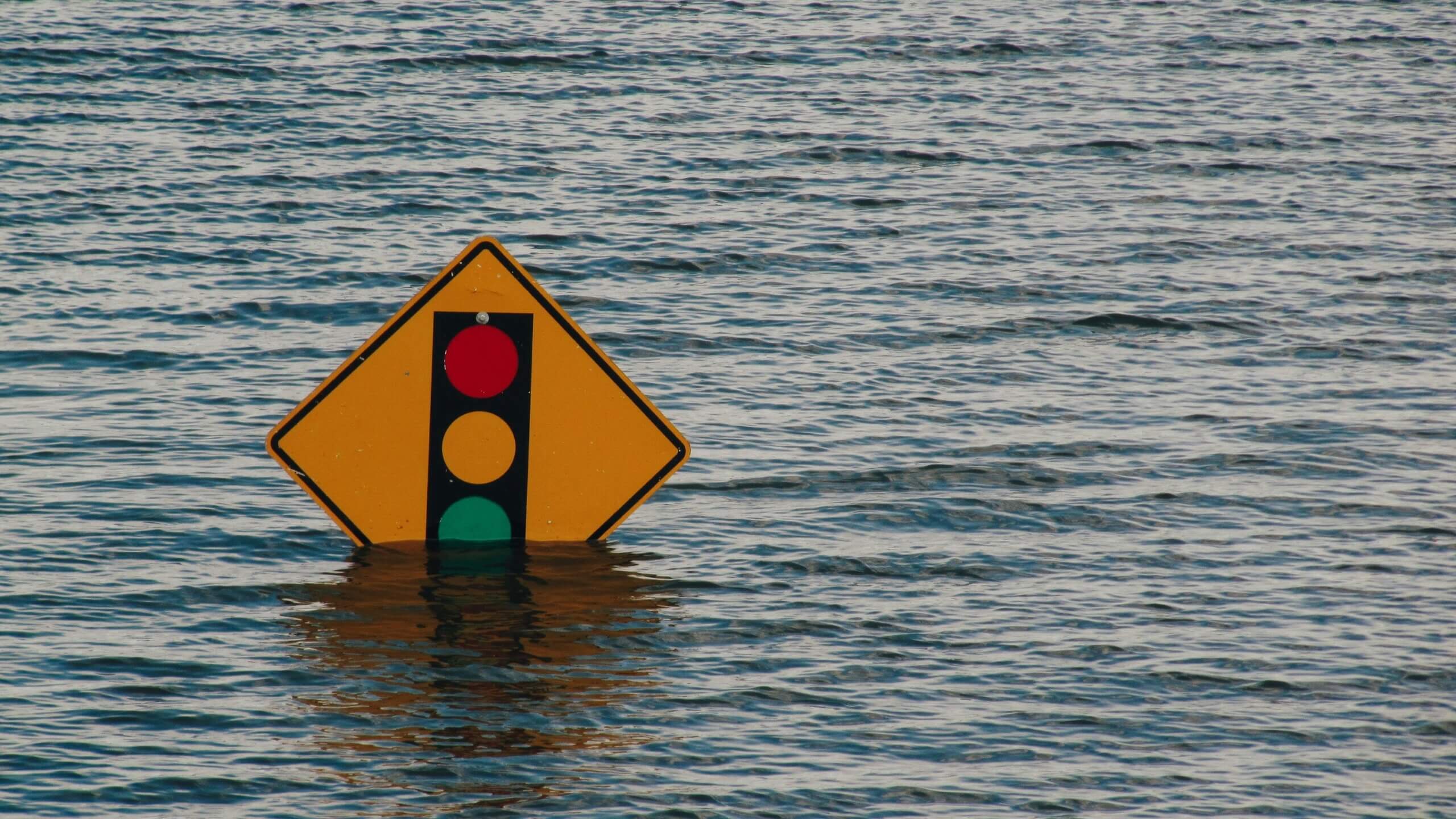 A traffic sign in water showing signs of flooding