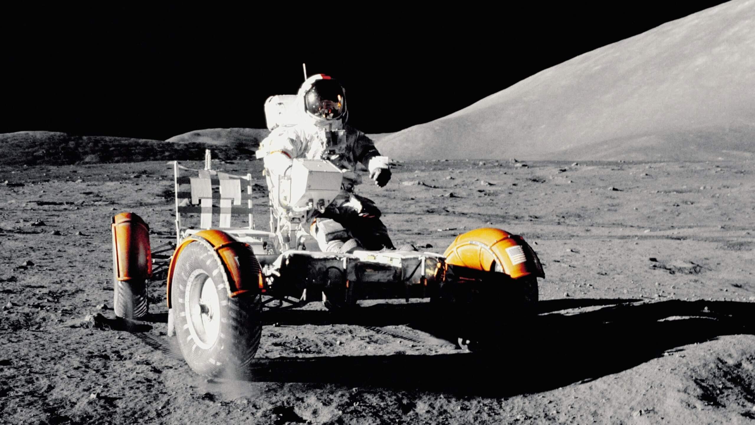 An astronaut driving a lunar rover on the moon