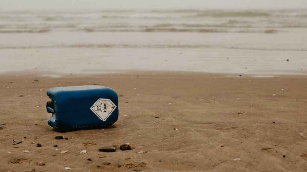 Toxic waste in a plastic container on a beach