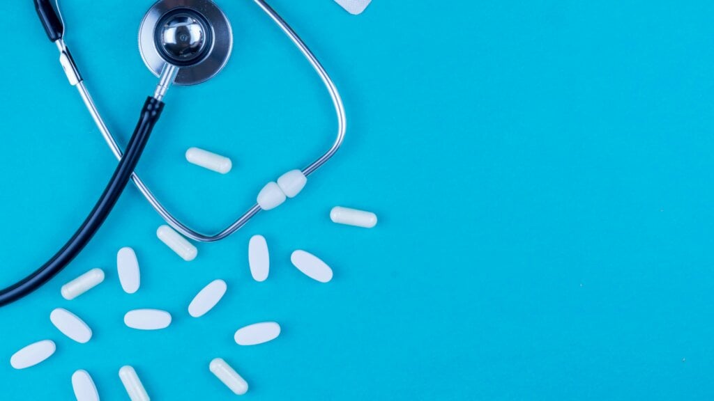 Un stéthoscope et des pilules sur une table bleue