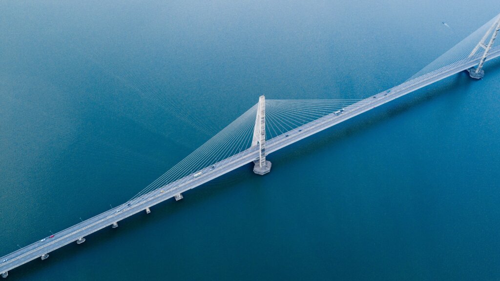 pelēks betona tilts uz ūdenstilpes aerofotogrāfijas attēlā