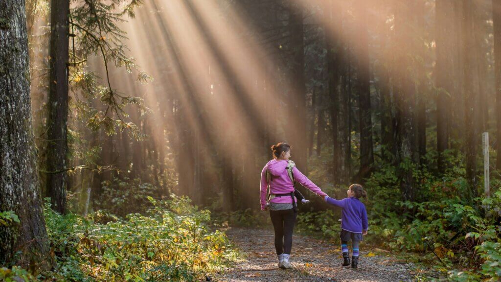 o femeie și un copil mergând într-o pădure